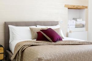 a bed with white and purple pillows on it at VILLA GENTILE RESORT E SPA in Cassano delle Murge +78 photos