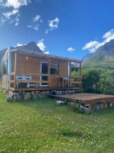 a cabin in a field with mountains in the background at LA CABAÑA DEL CAMPO in Ushuaia