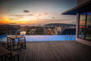 a rooftop pool with a table and chairs on a building at Ber-Santai @Sky Hotel Suites in Kota Kinabalu
