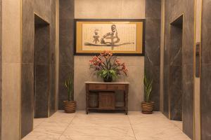 a hallway with a table with a vase of flowers at Ber-Santai @Sky Hotel Suites in Kota Kinabalu +33 photos