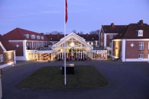 een groot gebouw met een vlag ervoor bij Milling Hotel Park in Middelfart