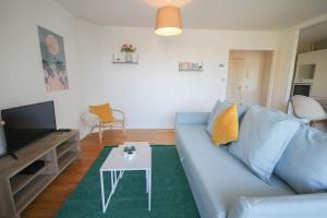 a living room with a blue couch and a table at Apartment 2ch elevator, terrace, private parking. in Lille