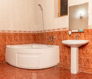 ein Badezimmer mit einer Badewanne und einem Waschbecken in der Unterkunft Venesa in Tbilisi City