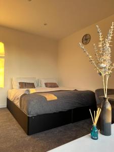 a bedroom with a bed and a clock on the wall at Alban Suites in Saint Albans