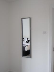 een spiegel aan een muur naast een bed bij Alban Suites in Saint Albans