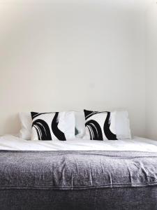 een bed met zwarte en witte kussens erop bij Alban Suites in Saint Albans