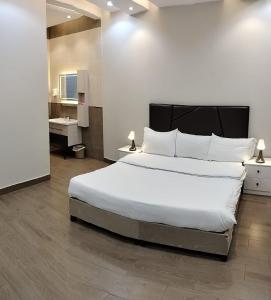 um quarto com uma grande cama branca e uma casa de banho em منتجع الكناري للفلل الفندقية الفاخرة Canary resort em Taif