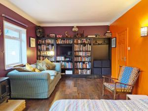 a living room with a couch and book shelves with books at Coastal - Wittering in West Wittering