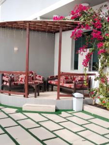 eine Terrasse mit Bänken und rosa Blumen auf einem Gebäude in der Unterkunft منتجع الكناري للفلل الفندقية الفاخرة Canary resort in Ta'if