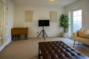 uma sala de estar com uma televisão e um sofá em Coastal Haven Ilfracombe by StayStaycations em Ilfracombe