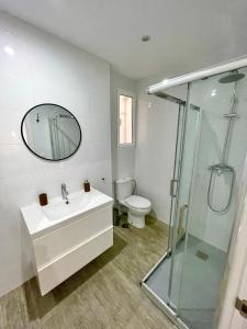 a bathroom with a sink and a toilet and a mirror at Elegante apartamento 6-8pax AV Palmera 3D 2B in Seville