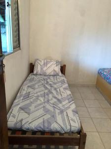 Una cama en una habitación con un edredón. en Quartos em Alcobaça, en Alcobaça
