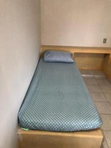 Cama pequeña en una esquina de habitación en Quartos em Alcobaça, en Alcobaça