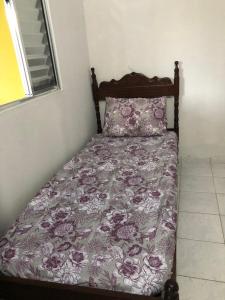 a bed in a bedroom with a purple bedspread at Quartos em Alcobaça in Alcobaça