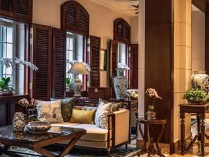 a living room with a couch and a table at Sofitel Legend Metropole Hanoi in Hanoi