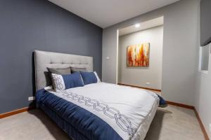 a bedroom with a large bed with blue walls at Confortable apartamento / zona 1 in Guatemala