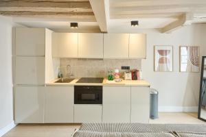 una cocina con armarios blancos y fregadero en 42.Typical Parisian Flat#4pers#Le Marais#Beaubourg, en París