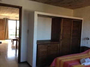 a bedroom with a bed and a wooden closet at Las Pakas in La Paloma