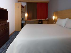 uma grande cama branca num quarto de hotel em Ibis Yaroslavl Center em Yaroslavl