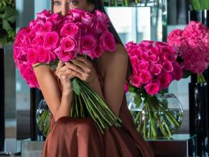 una mujer está sosteniendo un gran ramo de rosas rosas en Sofitel Abu Dhabi Corniche, en Abu Dabi