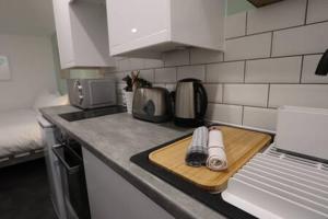 a kitchen counter with a cutting board and a laptop at The Snug- Studio in Portishead with Parking in Portishead