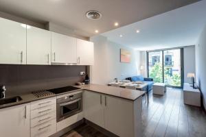 une cuisine avec des placards blancs et une salle à manger dans l'établissement Espais Blaus Apartments, à Barcelone 17 autres photos