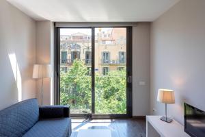 sala de estar con sofá y ventana grande en Espais Blaus Apartments, en Barcelona