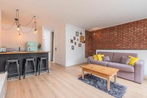 a living room with a couch and a table at Appartement lumineux avec rooftop et garage privé. in Lille