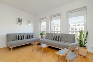 a living room with two couches and a table at Spacious & Bright Apartment with Parking Poznań by Renters in Poznań
