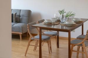 a dining room table with chairs and a couch at Spacious & Bright Apartment with Parking Poznań by Noclegi Renters in Poznań