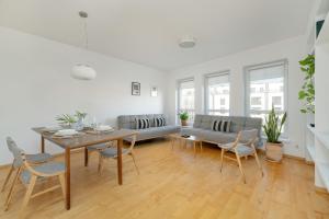 a white living room with a table and chairs at Spacious & Bright Apartment with Parking Poznań by Noclegi Renters in Poznań +22 photos