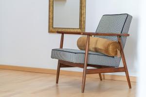 a chair in a room with a mirror at Spacious & Bright Apartment with Parking Poznań by Renters in Poznań