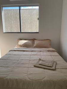 Una cama con una toalla encima en un dormitorio en AP Locação de Diárias Lajes/RN en Lajes