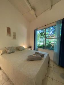 a bedroom with a large bed with a large window at Posada El Ceibo in Puerto Iguazú