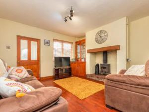 a living room with two couches and a fireplace at Pass the Keys Cosy Miners Cottage in Telford
