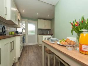 a kitchen with a table with a plate of food on it at Pass the Keys Cosy Miners Cottage in Telford