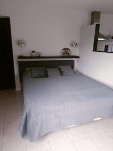 een bed in een witte kamer met een bedframe bij De Lindehoeve Appartement de Pompestraat in Vledder