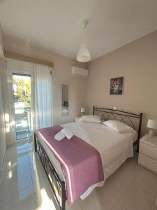 una camera con un grande letto e un balcone di Rita's Appartements and Studios a Karpathos