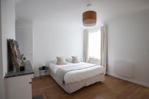 a white bedroom with a bed and a window at Appartement L2 ARENA Gare Centre in Reims