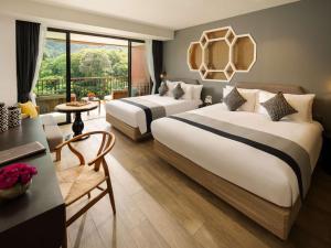 ein Hotelzimmer mit 2 Betten und einem Balkon in der Unterkunft Avista Grande Phuket Karon - MGallery in Karon Beach