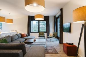 a living room with a couch and a table at Luxe Villa op park Duinzicht (huis 704) - Ouddorp in Ouddorp