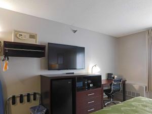 a hotel room with a television and a desk with a bed at Quality Inn Colchester - Burlington in Burlington