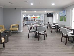 a waiting room with tables and chairs and a kitchen at Quality Inn Colchester - Burlington in Burlington
