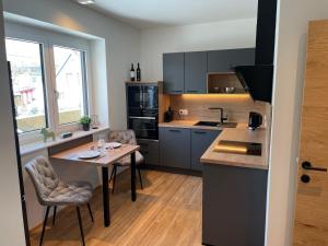 a kitchen with a small table and a table and chairs at Lake & Town Apartments Klagenfurt in Klagenfurt