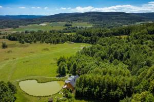 une vue aérienne sur un pâturage avec une maison et deux étangs dans l'établissement Folwark Wrzosówka Holiday Home, à Kłopotnica