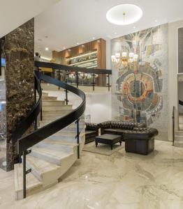 un vestíbulo con una escalera de caracol y una pared de mosaico en Hotel Royal Inn en Belgrado