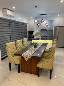 a kitchen with a dining table and yellow chairs at Villa Tobias San Juan Batangas in Batangas City