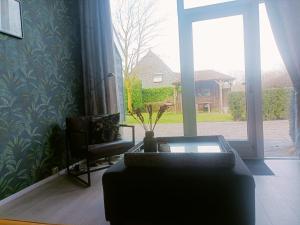 - un salon avec un canapé et une fenêtre dans l'établissement De Lindehoeve Appartement de Deel, à Vledder