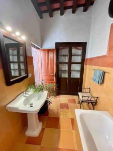 y baño con lavabo blanco y bañera. en GINVA - Casa palacio La Templanza, en El Puerto de Santa María