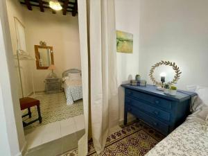 1 dormitorio con tocador azul y espejo en GINVA - Casa palacio La Templanza, en El Puerto de Santa María